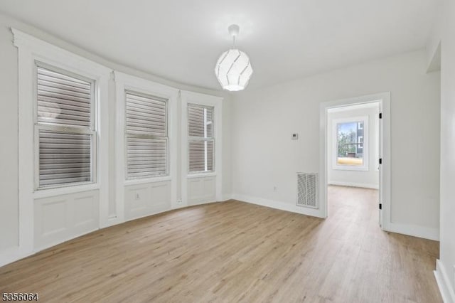 unfurnished dining area with light wood-style flooring and baseboards