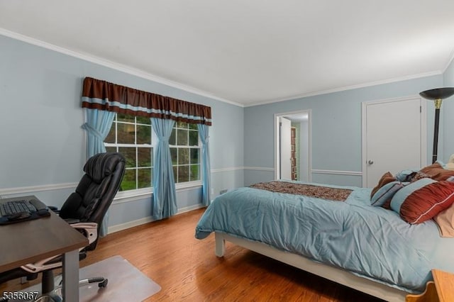bedroom featuring ornamental molding, wood finished floors, an office area, and baseboards