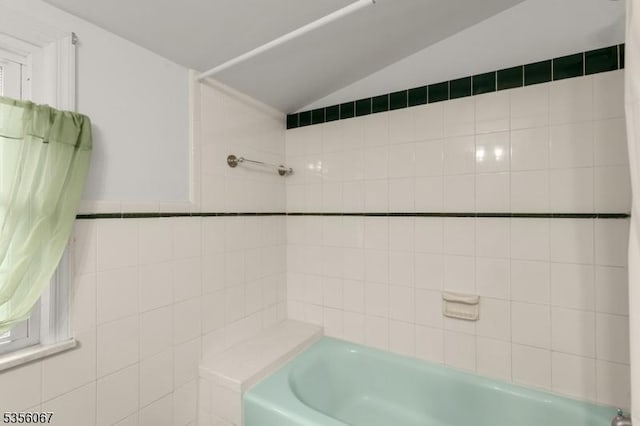 bathroom featuring lofted ceiling and shower / bathtub combination