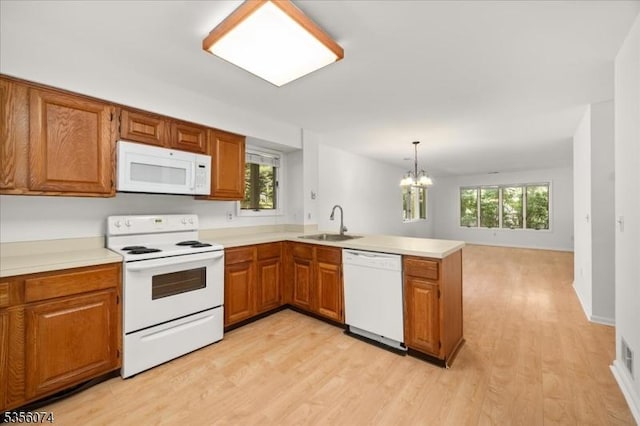 41 Troon Ter, Clinton Twp, NJ 08801 - kitchen with white appliances, a sink, a peninsula, a chandelier, and light wood-type flooring