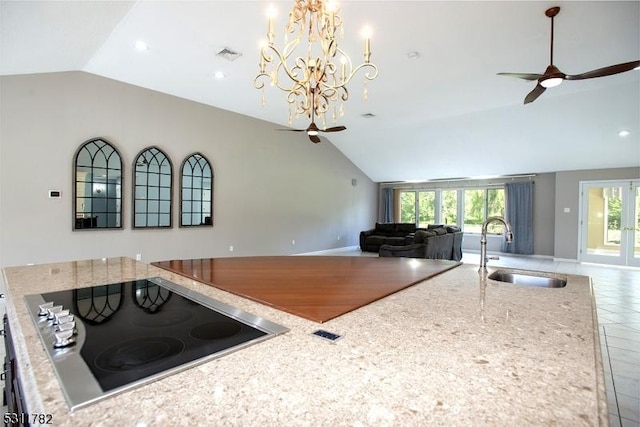 kitchen with a sink, a ceiling fan, vaulted ceiling, black electric cooktop, and open floor plan