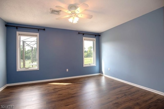 empty room with ceiling fan, dark wood-style flooring, and baseboards