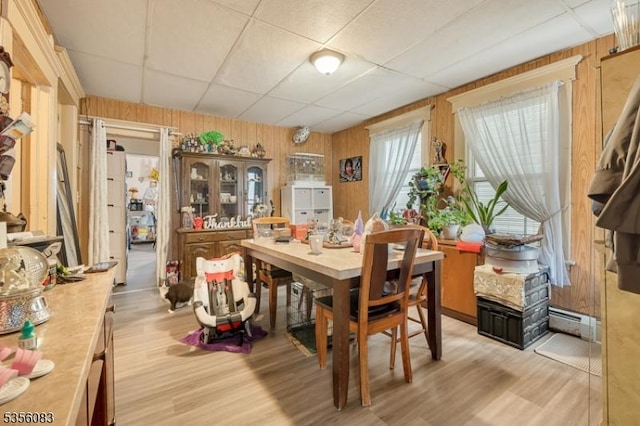 124 E Main St, Paterson City, NJ 07522 - dining room with a drop ceiling, light wood finished floors, a baseboard radiator, and wood walls