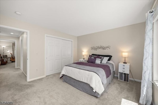 carpeted bedroom featuring baseboards and a closet