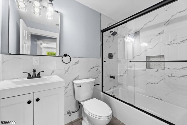 19 Oak Rd, Boonton Twp, NJ 07005 - bathroom with tile walls, toilet, vanity, combined bath / shower with glass door, and wainscoting
