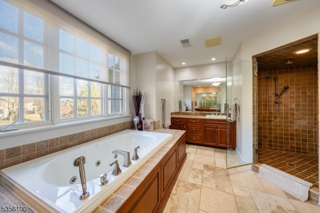 bathroom featuring a tile shower, a tub with jets, vanity, and recessed lighting