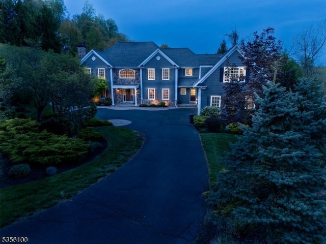 view of front of property with curved driveway and a chimney