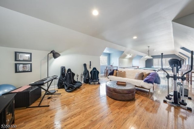 workout room with vaulted ceiling, wood finished floors, healthy amount of natural light, and baseboards