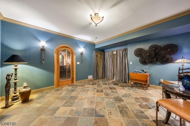 hall featuring baseboards, ornamental molding, and stone finish flooring