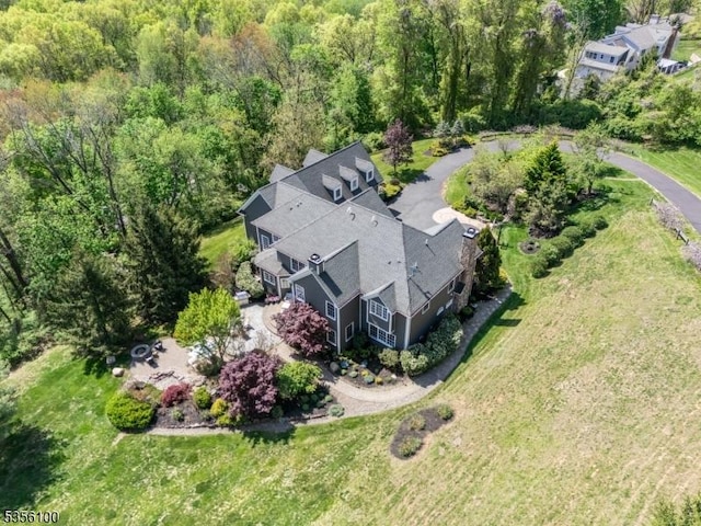 aerial view of property and surrounding area featuring a heavily wooded area