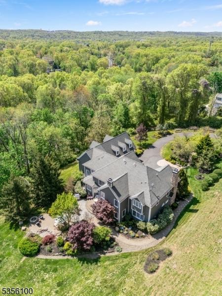 aerial view of property and surrounding area with a heavily wooded area