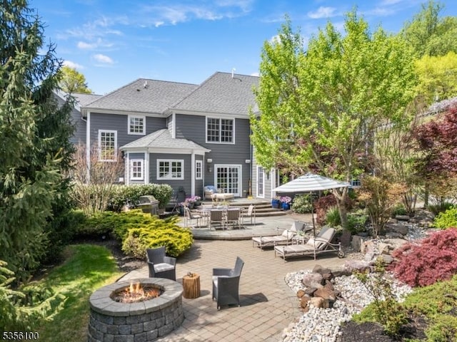 back of house featuring an outdoor fire pit, a patio, and roof with shingles