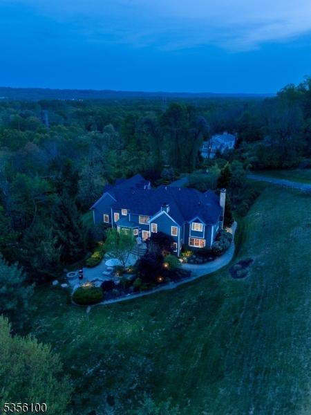 aerial view of property and surrounding area featuring a forest