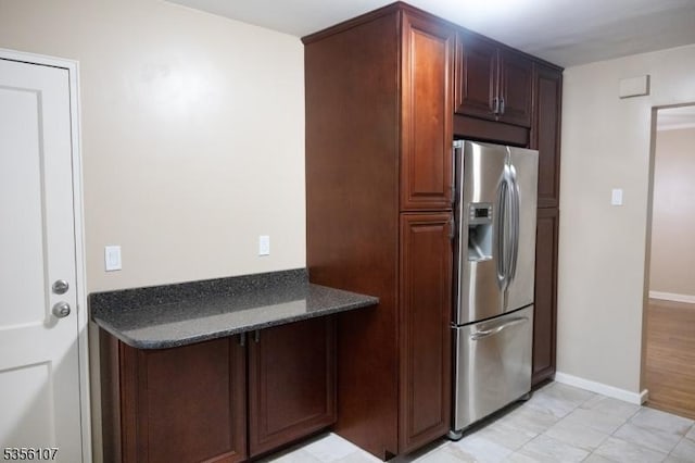 kitchen featuring stainless steel fridge and baseboards