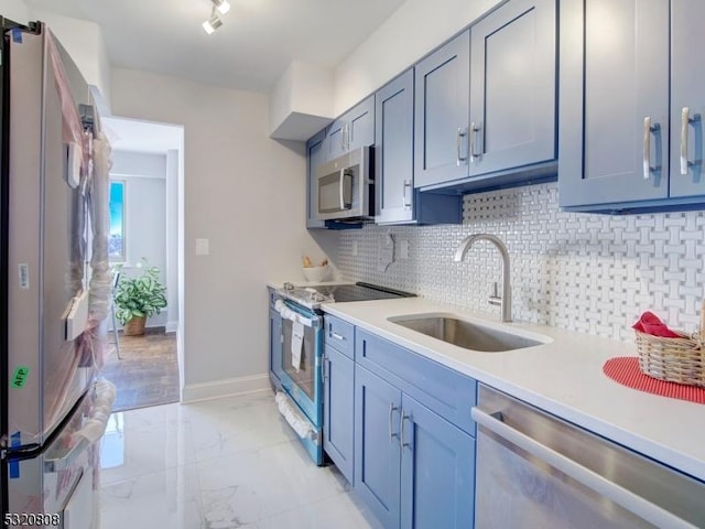 kitchen featuring stainless steel appliances, a sink, tasteful backsplash, light countertops, and baseboards