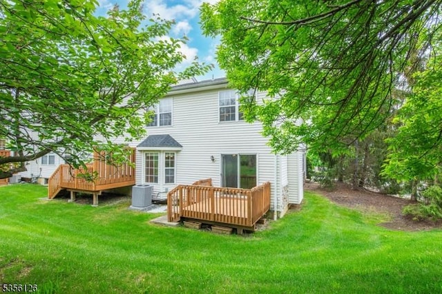 rear view of house with a wooden deck, central air condition unit, and a lawn