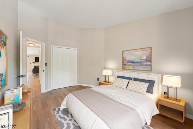 bedroom featuring baseboards, a closet, and wood finished floors