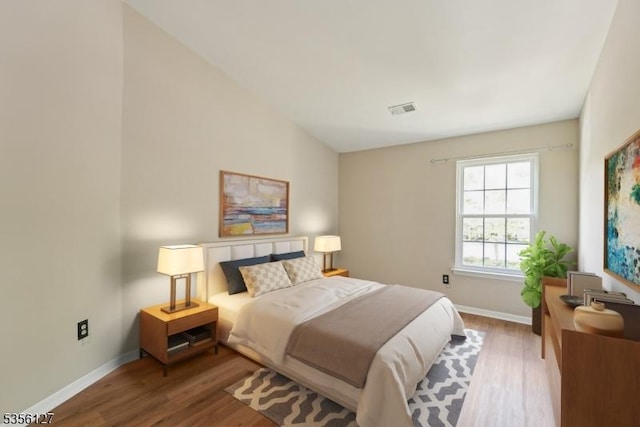 bedroom featuring visible vents, wood finished floors, and baseboards