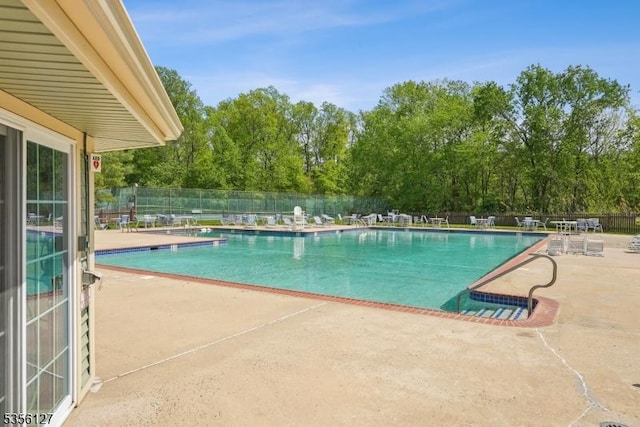 community pool featuring a patio area and fence