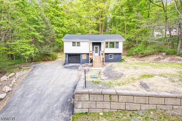 10 Maple Dr, Vernon Twp, NJ 07461 - split foyer home featuring driveway, a view of trees, and a garage