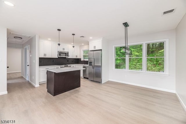 10 Maple Dr, Vernon Twp, NJ 07461 - kitchen with stainless steel appliances, baseboards, a kitchen island, light wood-style flooring, and backsplash