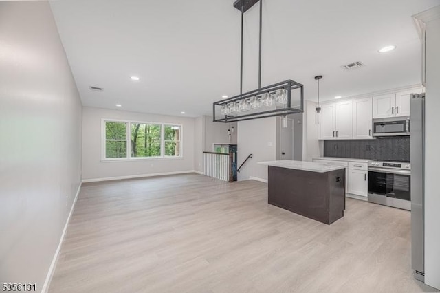 10 Maple Dr, Vernon Twp, NJ 07461 - kitchen featuring appliances with stainless steel finishes, baseboards, white cabinetry, tasteful backsplash, and light wood-style floors