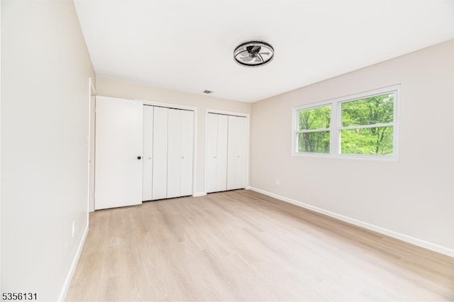 10 Maple Dr, Vernon Twp, NJ 07461 - unfurnished bedroom featuring two closets, baseboards, and light wood-style flooring