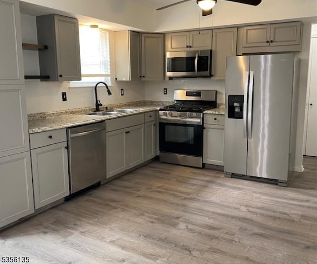 kitchen with stainless steel appliances, gray cabinets, and a sink