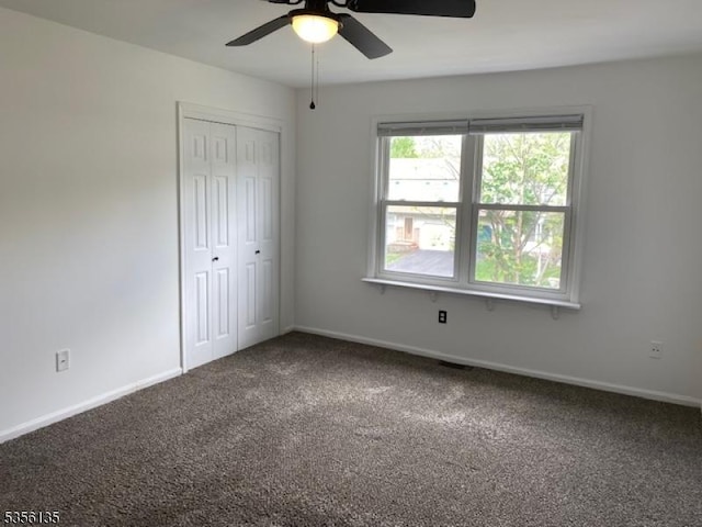 unfurnished bedroom with carpet, baseboards, a closet, and ceiling fan