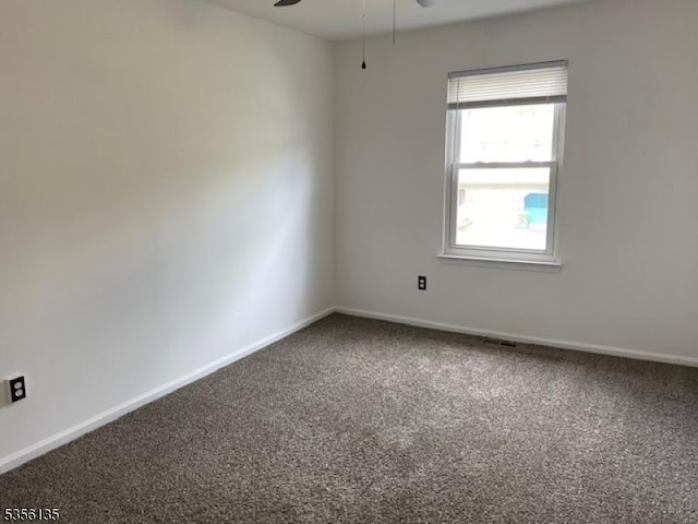 carpeted empty room with ceiling fan and baseboards