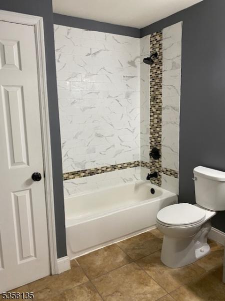 full bathroom featuring toilet,  shower combination, baseboards, and tile patterned flooring