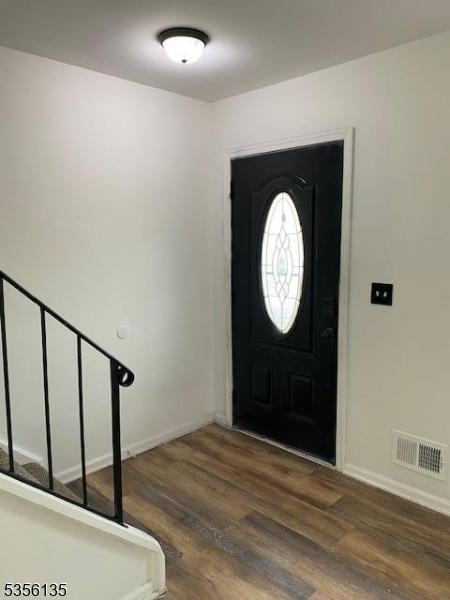 entrance foyer with wood finished floors, baseboards, and stairs