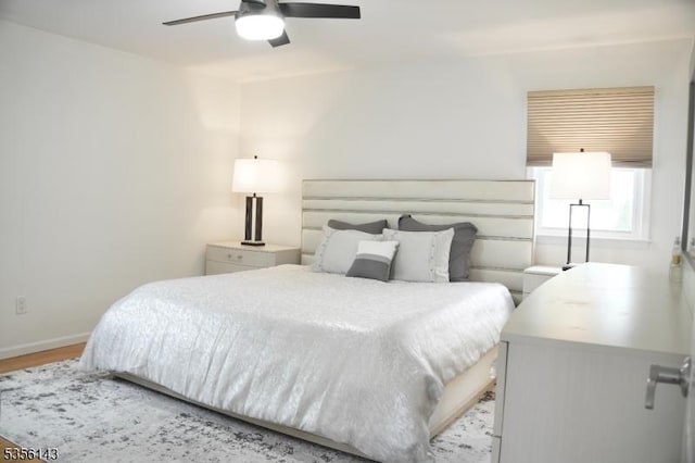 bedroom featuring baseboards, a ceiling fan, and wood finished floors