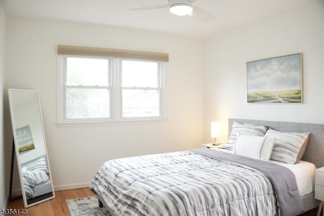 bedroom featuring wood finished floors, baseboards, and ceiling fan