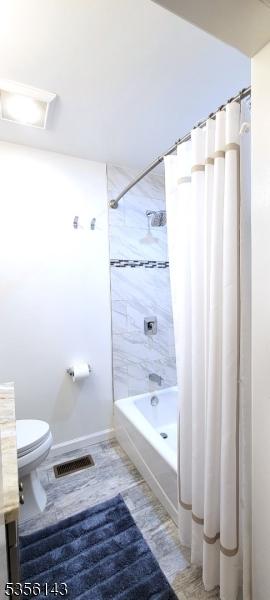 bathroom with toilet, vanity, visible vents, and shower / bathtub combination with curtain