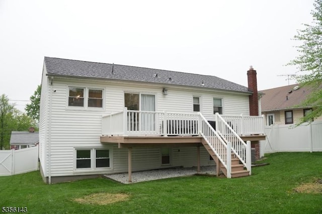 back of house featuring a lawn, a wooden deck, and a fenced backyard