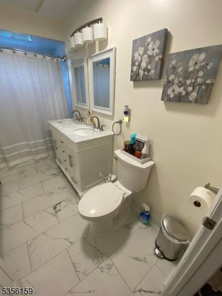 66 Lexington Ave, Rochelle Park Twp, NJ 07662 - full bathroom with marble finish floors, toilet, vanity, and curtained shower
