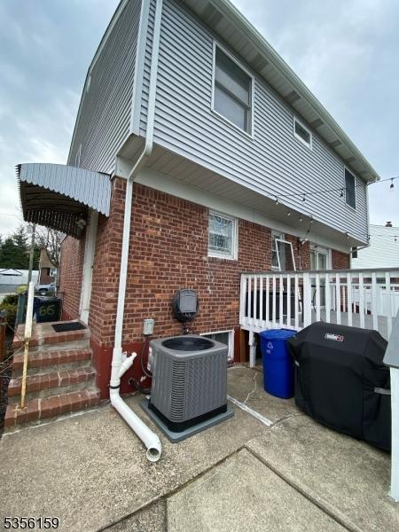 66 Lexington Ave, Rochelle Park Twp, NJ 07662 - rear view of property featuring central AC unit and brick siding