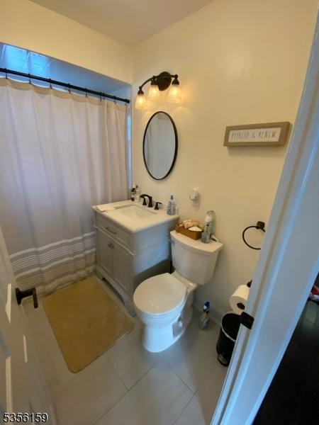 66 Lexington Ave, Rochelle Park Twp, NJ 07662 - full bathroom featuring tile patterned flooring, toilet, vanity, and a shower with shower curtain