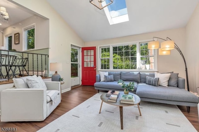 living area featuring wood finished floors, baseboards, a skylight, high vaulted ceiling, and a chandelier