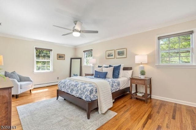 bedroom featuring crown molding, multiple windows, a baseboard radiator, light wood-style floors, and baseboards