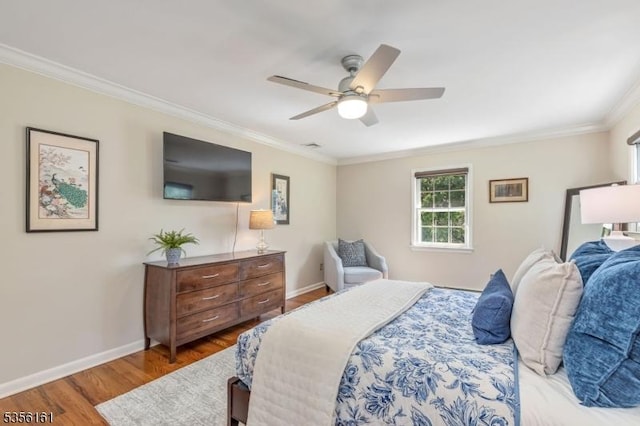bedroom with ornamental molding, wood finished floors, baseboards, and a ceiling fan