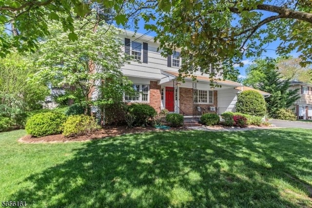view of front of property featuring brick siding and a front yard