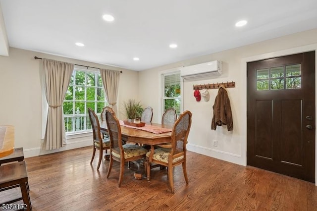 dining area with a wall unit AC, baseboards, wood finished floors, and recessed lighting