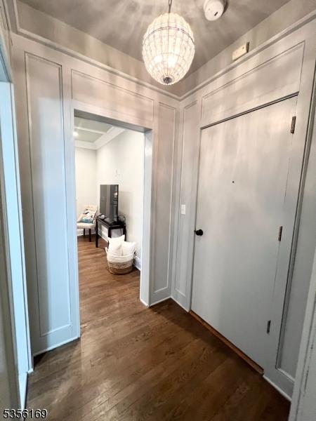 133 Summit Ave Unit 30, Summit City, NJ 07901 - corridor with a chandelier and dark wood-style floors
