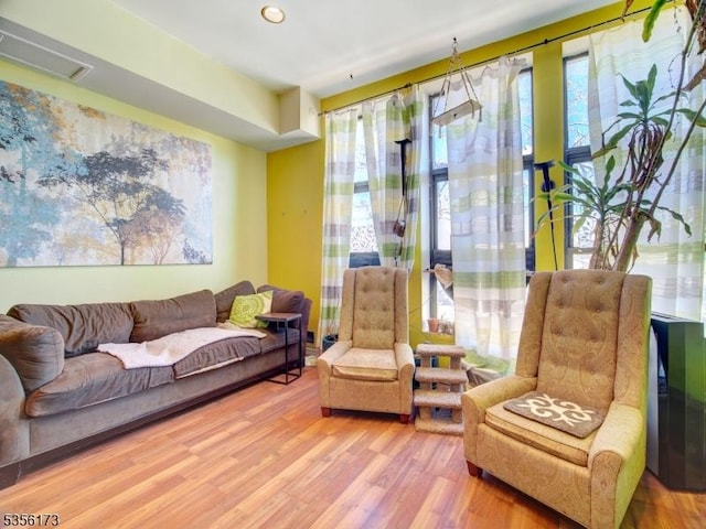 living area with recessed lighting, visible vents, and wood finished floors
