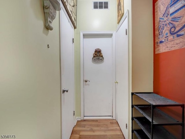 doorway with light wood finished floors and visible vents