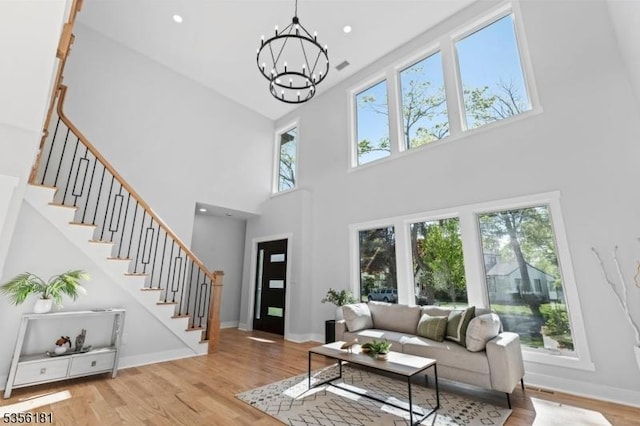 2227 Pine Ter, Scotch Plains Twp, NJ 07076 - living room featuring a towering ceiling, a chandelier, stairs, and wood finished floors