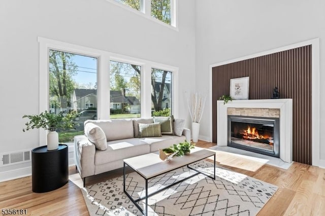 2227 Pine Ter, Scotch Plains Twp, NJ 07076 - living area featuring plenty of natural light, a fireplace with flush hearth, wood finished floors, and a high ceiling