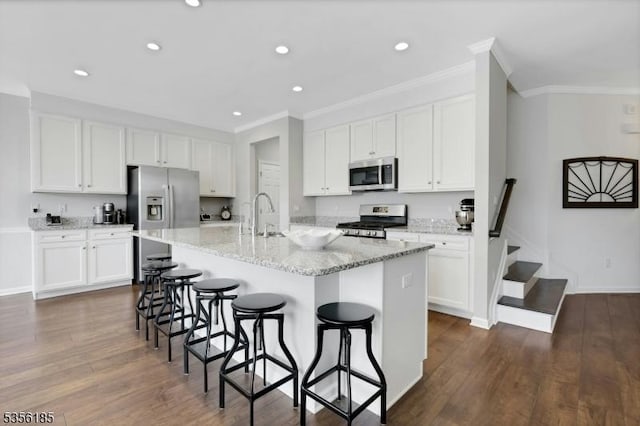 2 Lee Dr, Morris Twp, NJ 07960 - kitchen featuring appliances with stainless steel finishes, ornamental molding, a breakfast bar area, white cabinetry, and recessed lighting